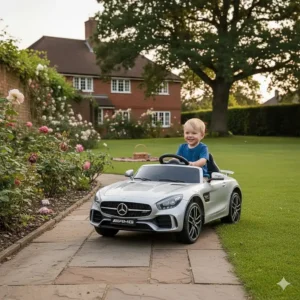 A young child driving a black Mercedes ride-on car on a paved garden path in the UK.