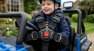 Close-up of a secure 5-point safety harness with padded straps and a quick-release button on a kids' 24v electric buggy.