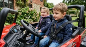 Close-up of two children securely fastened with adjustable safety harnesses and padded seats in a Polaris RZR style ride-on car.