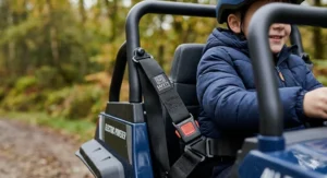 Close-up of a 3-point safety harness and padded roll cage on a kids' off-road electric buggy.