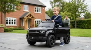 Young boy playing with a red ride-on car for toddlers on a wooden parquet floor in a British living room.