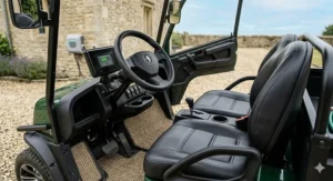 Interior dashboard and cockpit view of a two seat electric buggy showing the steering wheel, digital display, and side-by-side black leather seats.