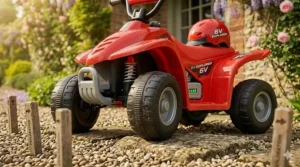 A 12V children's quad bike driving across a garden lawn to show its ability to handle grass better than a 6V version.