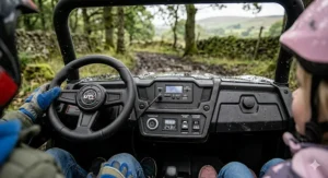 The realistic dashboard of a 4x4 UTV for kids including an MP3 player plug-in, battery indicator, and start button.