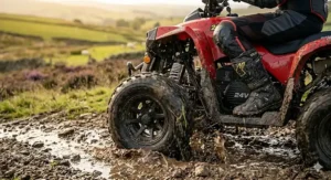 Close-up of the handlebars on a 24v quad bike showing the digital battery indicator display and twist-grip throttle controls.