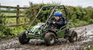 A 7-year-old driving a green off-road buggy through a muddy farm track, highlighting the knobby tyres and spray of wet earth.