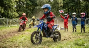 A young rider wearing protective gear riding a 24v electric dirt bike during a community dirt track race.