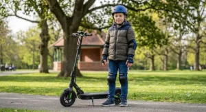 Young rider standing with his electric scooter wearing a protective helmet and full set of knee and elbow pads.