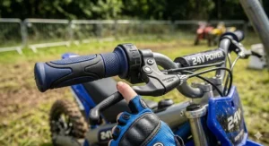 Detailed view of a child's hand using the ergonomic brake lever and speed settings on a 24v electric dirt bike.