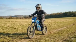 Bright LED headlight illuminated on a blue 24v electric dirt bike.