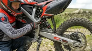 Detail view of the rear suspension system on a kids' electric dirt bike