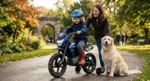 A child on a two-seater electric motorbike with stabilisers in a British park, accompanied by a parent and a Golden Retriever.