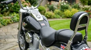 The 12v cruiser-style electric motorcycle partially assembled, showing the included UK battery charger and manual.