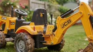 Close-up of a child using the lever controls on a ride-on tractor to operate the digger bucket.