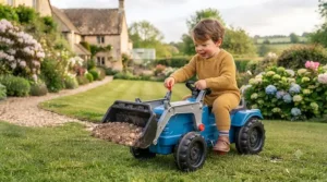 Child using the front loader bucket on a blue pedal tractor.