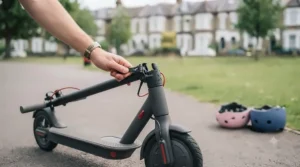 An adult hand folding the stem of a standing electric scooter, demonstrating how easy it is to pack down for storage or transport.