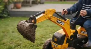 Child driving a robust JCB ride on digger across a concrete patio in the garden