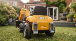 Close-up of the functional front scoop mechanism on a children's JCB ride-on digger