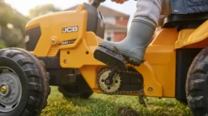 Close-up view of the working steering wheel and interactive dashboard features on an official licensed JCB ride-on tractor.