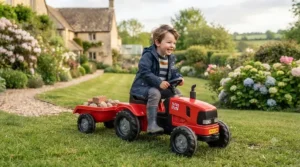 Red electric ride-on tractor with a detachable tipping trailer.