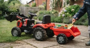 A child loading garden toys into the detachable trailer of their multi-function ride-on tractor.