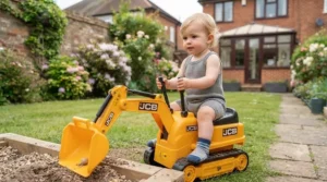Two-year-old child comfortably sitting on a miniature ride-on digger toy to demonstrate size scale.