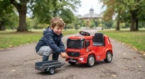 Young boy playing with a heavy-duty truck ride-on toy on a path in a British park