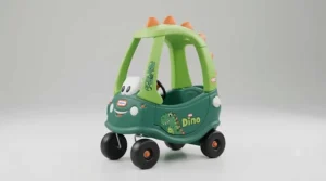 Front view of the green Cozy Coupe Dino ride-on showing its friendly dinosaur face and working horn.