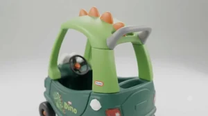 Rear view of the Cozy Coupe Dino ride-on showing the integrated parent push handle on the roof.