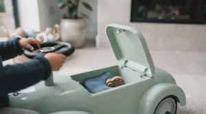 Detailed view of the robust, weather-resistant plastic wheels on an outdoor foot-to-floor car designed for rough tarmac.