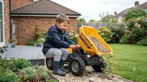 Child operating the working tipping bed feature on an electric ride-on dumper truck outdoors.