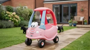 Front three-quarter view of the pink and blue Cozy Coupe ride-on car showing its classic smiling face grill.