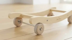Side profile showing the wooden frame and smooth caster wheels of the rolling plush animal ride-on.