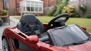 Close-up of a toddler sports car ride-on showing secure seat belts, smooth steering wheel, and safety features.