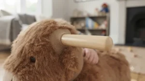 Close-up showing the soft, child-friendly fabric texture of the rolling plush animal ride-on.