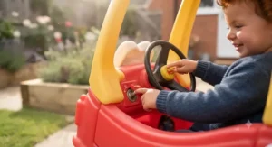 Child interacting with the clicking ignition switch and fuel cap on a licensed character Cozy Coupe toy car.