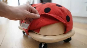 Removable plush ladybird cover being taken off the Wheelybug base for easy cleaning.
