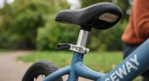 Close-up of the quick-release adjustable seat mechanism on a lightweight metal balance bike