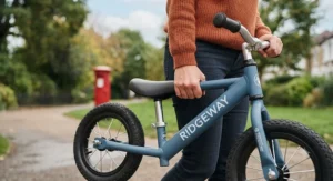 Parent easily carrying a lightweight metal balance bike by the frame after a trip to the local playground