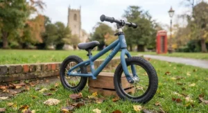 Close-up of the height-adjustable padded saddle on a black metal balance bike.