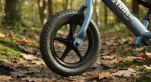 Close-up of air-filled pneumatic tyres on a metal balance bike for a smoother ride over rough park terrain.